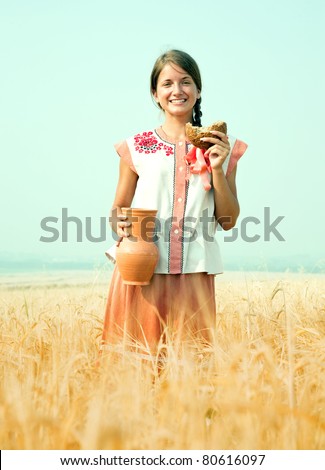 Girl with bread and jug of milk  at rye field