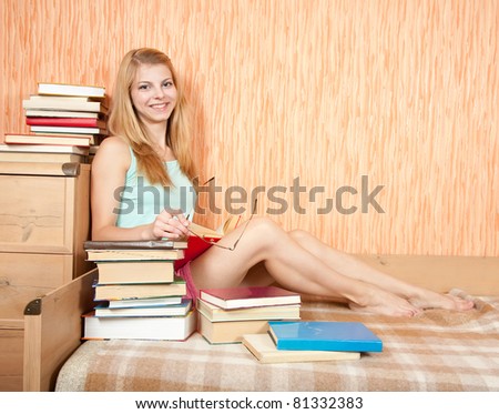 A young woman studying hard on sofa at home
