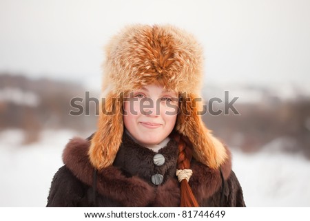 Portrait of smiling woman in coat and fur cap