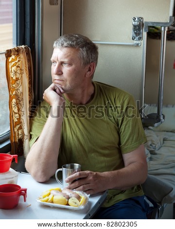 Mature man looking to window in sleeper train