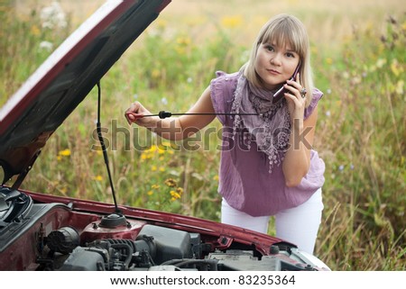 Young woman trying to fix the car