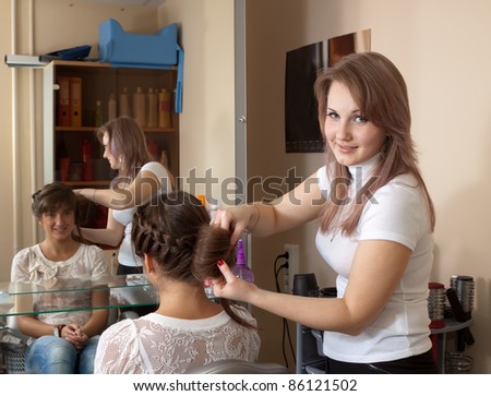 Female hair stylist working with long-haired girl