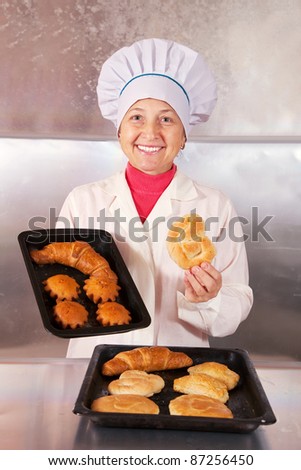 Baker with fresh pastries on trays
