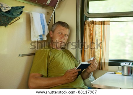 Mature man reading book  in sleeper train