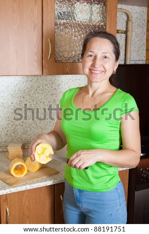 Woman cooking stuffed vegetable marrow in her kitchen. See in series stages of cooking of stuffed vegetable marrow.
