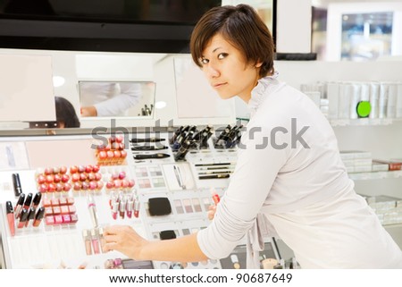 young woman chooses the cosmetic  at cosmetics  shop