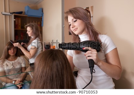 Female hairdresser working with hair dryer