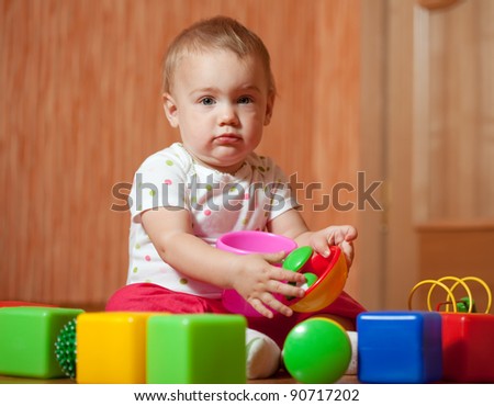 tranquil baby girl plays with toy blocks in home