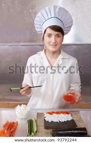 Cook making  Japanese sushi rolls with caviar
