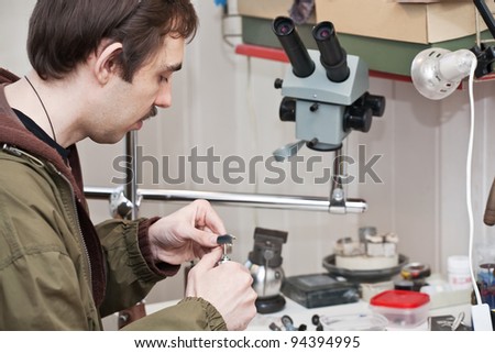 Male jeweller is working at jeweller\'s workshop