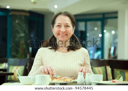 Woman having breakfast in hotel restaurant