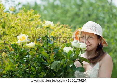 Mature woman in rose plant at garden