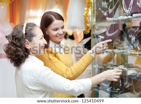 Smiling women  chooses bridal accessories at store of wedding fashion