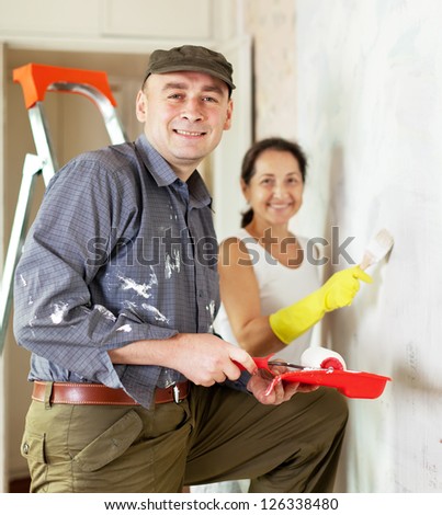 Happy woman and man makes repairs in home together