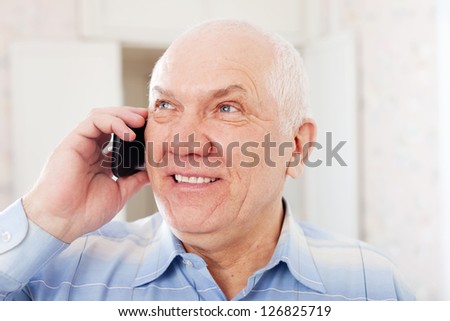Portrait of positive mature man speaks by phone
