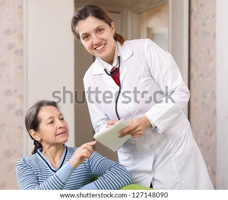 friendly doctor talks with  joyful mature woman at hospital. Focus on patient