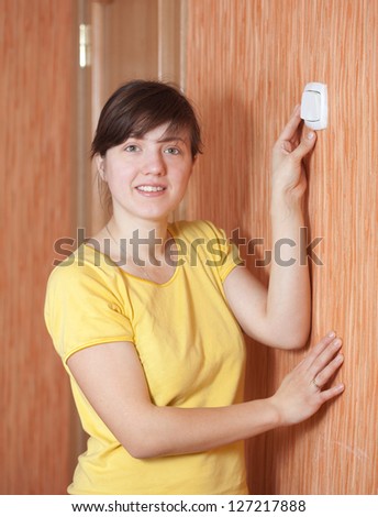 Young woman turning off the light-switch in home - stock photo