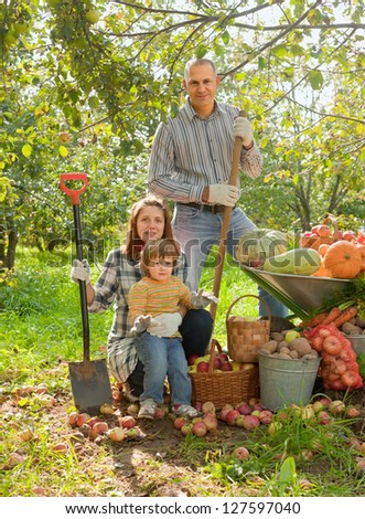 Happy  family with vegetables harvest in garden