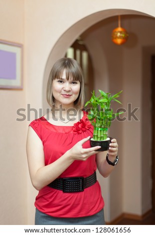 Girl with lucky bamboo plant at her home
