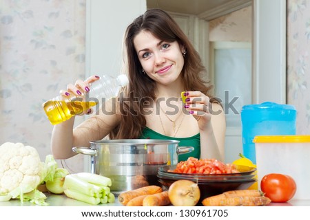 beautiful housewife cook vegetables with oil at her kitchen at home