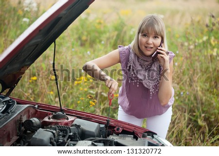 Young woman trying to fix the car