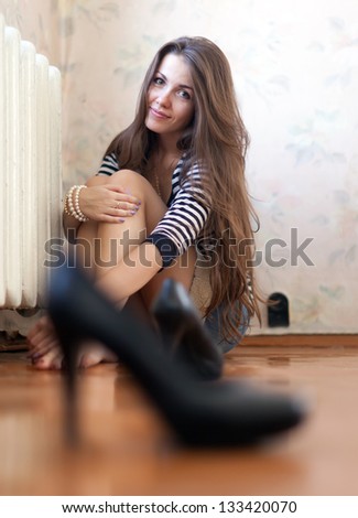 Lonely girl sitting on the floor in the corner