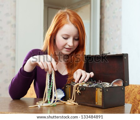 teen girl chooses jewelry in treasure chest