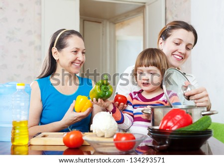 Happy family together cooking vegetarian lunch with vegetables at home