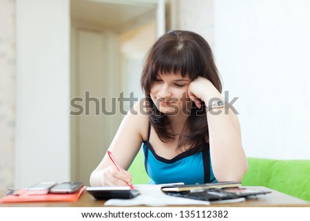 Young housewife with utility bills  at her home