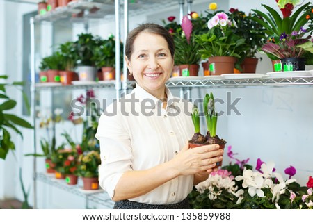 Happy  woman with hyacinth (Hyacinthus) in flower store