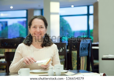 Woman having breakfast in hotel restaurant