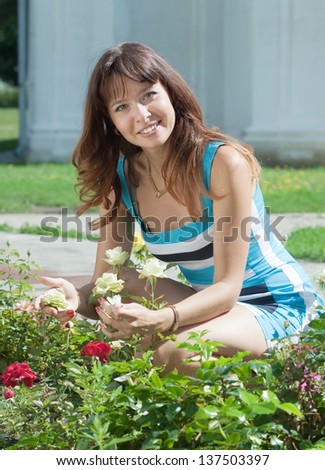 Female gardener in roses plant at garden
