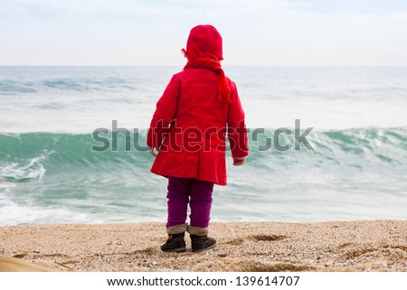 Baby  on sand beach in cold windy day