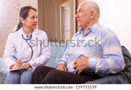 Mature man complaining  to doctor about tummy-ache at medical hospital