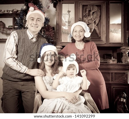 Imitation of antique photo of happy family in Santa hat celebrating Christmas