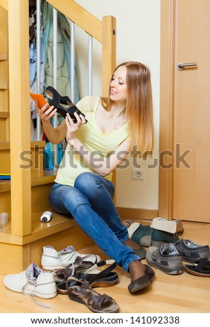 Long-haired blonde woman with shoes at home