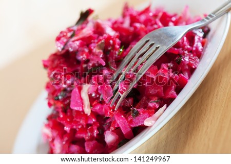 Vegetable salad with grated beets in white plate