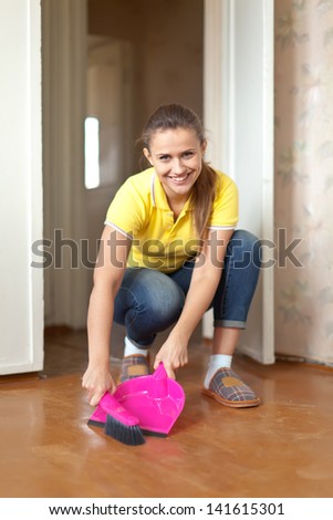 Girl sweeps the floor at home