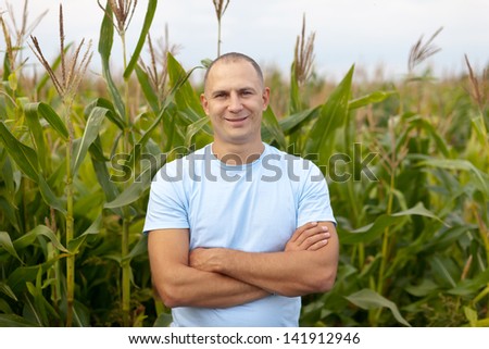 Happy  farmer in field of corn