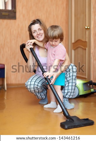 Family chores with vacuum cleaner in living room