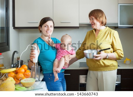 Happy women of three generations with blender in  kitchen