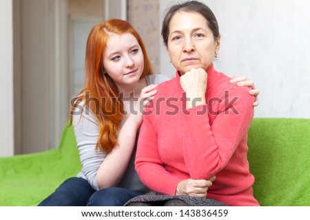 Teen girl asks for forgiveness from her mother. Focus on mature woman