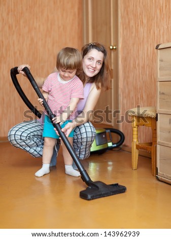 Family chores with vacuum cleaner in living room