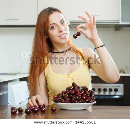 young woman with cherries in home