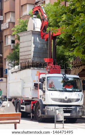 BARCELONA, CATALONIA - JUNE 23: Garbage truck collects garbage dumpster in June 23, 2013 in Barcelona, Catalonia.   Recycling truck picking up bin