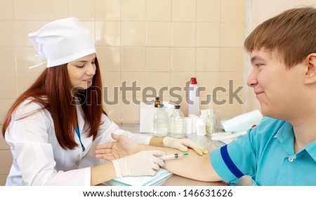 nurse makes to man an intravenous injection. Focus on man