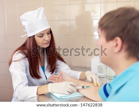 nurse makes to man an intravenous injection. Focus on woman