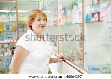 Mature woman near counter in pharmacy drugstore