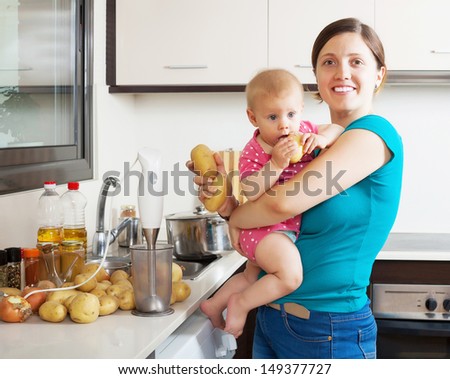 Happy mother and child  with blender in kitchen at home