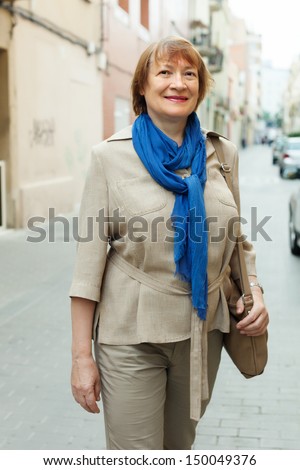 Outdoor portrait of mature woman wearing scarf in city street